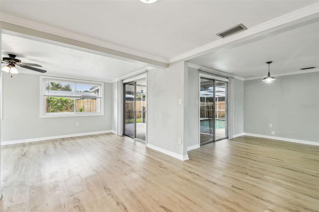 empty room with ceiling fan, visible vents, crown molding, wood finished floors, and baseboards