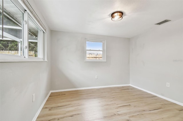 spare room with visible vents, baseboards, and wood finished floors