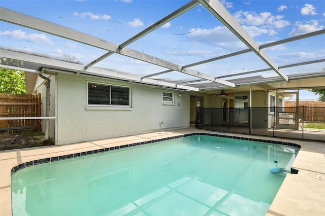 view of swimming pool with a ceiling fan, a patio area, glass enclosure, fence, and a fenced in pool