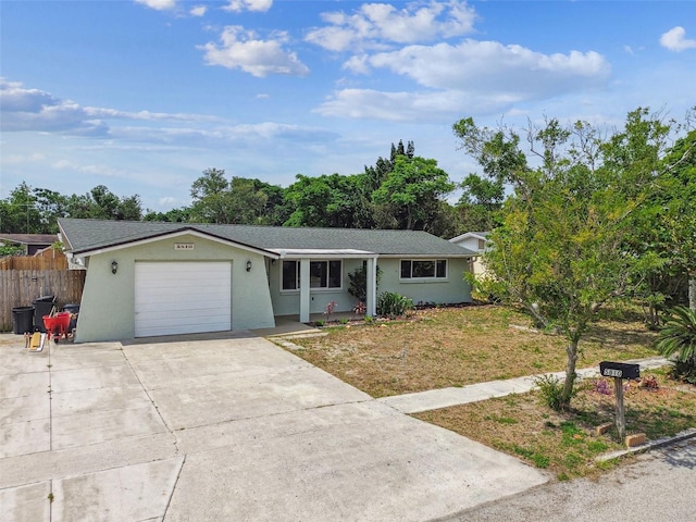 single story home with concrete driveway, an attached garage, fence, and stucco siding