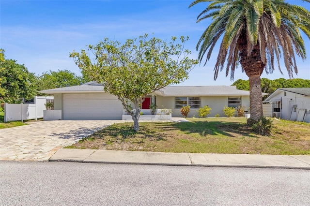3654 Warbler Dr, New Port Richey, FL 34652 - ranch-style home with a front lawn, fence, a garage, stucco siding, and decorative driveway