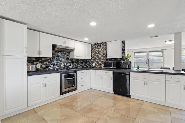 3654 Warbler Dr, New Port Richey, FL 34652 - kitchen with dark countertops, under cabinet range hood, a sink, and appliances with stainless steel finishes