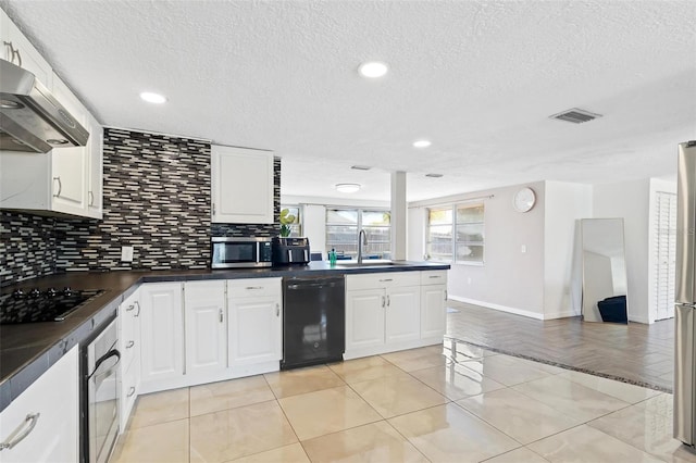 3654 Warbler Dr, New Port Richey, FL 34652 - kitchen with under cabinet range hood, dark countertops, visible vents, a sink, and black appliances