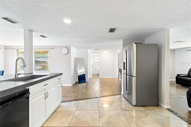 3654 Warbler Dr, New Port Richey, FL 34652 - kitchen with dark countertops, dishwasher, a sink, freestanding refrigerator, and white cabinetry