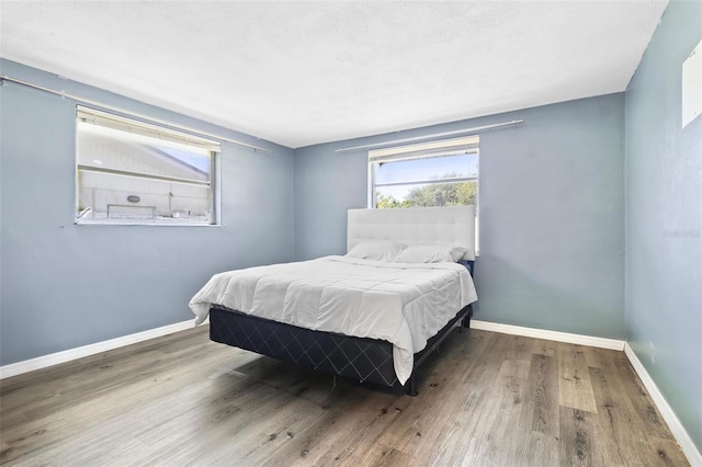 3654 Warbler Dr, New Port Richey, FL 34652 - bedroom featuring baseboards and wood finished floors