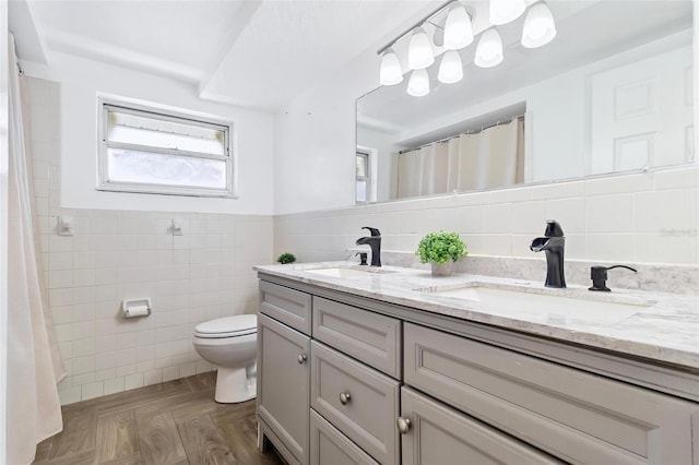 3654 Warbler Dr, New Port Richey, FL 34652 - bathroom with tile walls, a sink, double vanity, and toilet