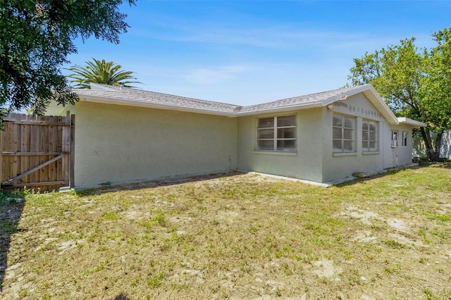 3654 Warbler Dr, New Port Richey, FL 34652 - rear view of property featuring fence, a lawn, and stucco siding