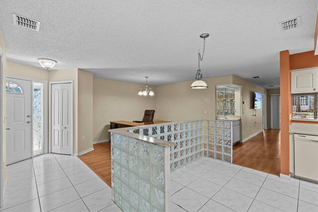 2023 Golfview Dr Unit 2023, Tarpon Springs, FL 34689 - kitchen with white dishwasher, light tile patterned floors, a textured ceiling, and baseboards