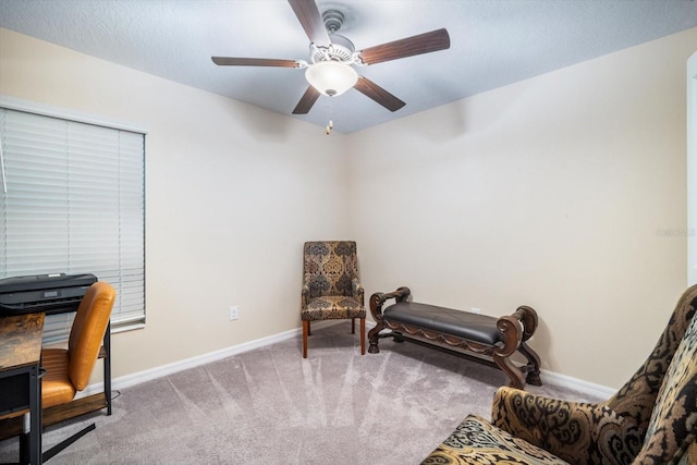 living area with ceiling fan, baseboards, and carpet