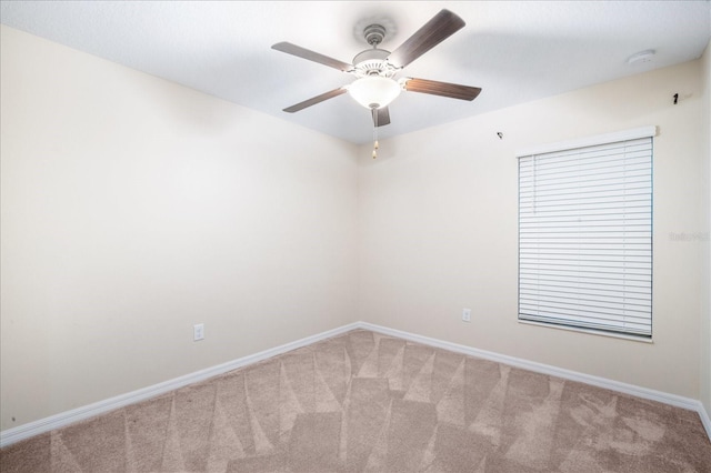 empty room with ceiling fan, carpet flooring, and baseboards