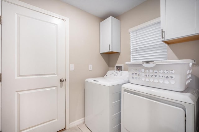 washroom with washing machine and dryer, baseboards, and cabinet space