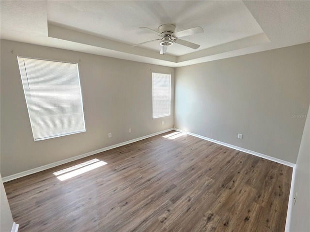 12604 Montford Ln, Riverview, FL 33579 - empty room with ceiling fan, baseboards, wood finished floors, and a raised ceiling