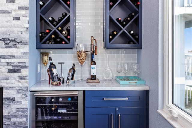 bar with tasteful backsplash, beverage cooler, and a dry bar