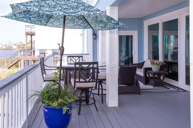 deck featuring a water view and outdoor dining area
