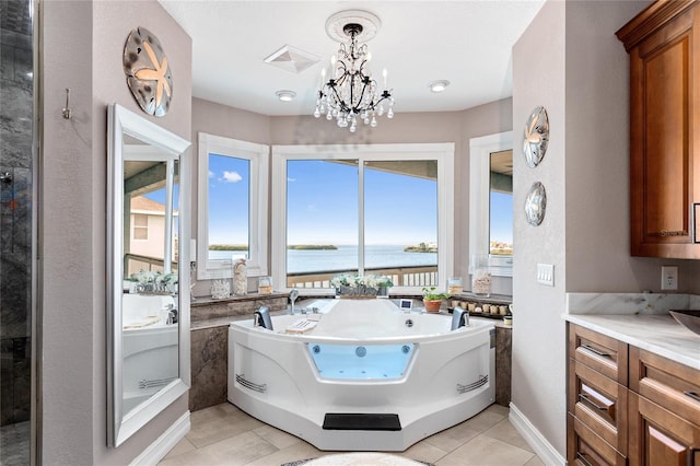 bathroom with a chandelier, a water view, vanity, visible vents, and a jetted tub