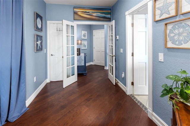 corridor with baseboards, wood finished floors, and french doors