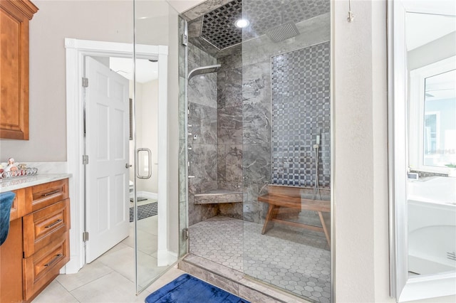 bathroom with tile patterned flooring, a shower stall, and vanity
