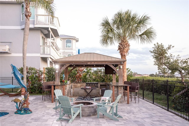 view of patio featuring fence, a fire pit, a gazebo, and outdoor dry bar