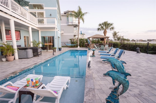 community pool with fence, a gazebo, and a patio area