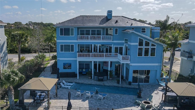 back of house featuring a gazebo, fence private yard, a patio, an outdoor living space with a fire pit, and a balcony