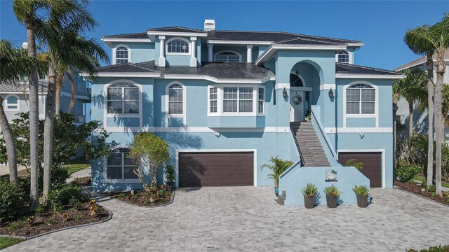 2111 Alexis Ct, Tarpon Springs, FL 34689 - view of front of house featuring an attached garage, stucco siding, and decorative driveway