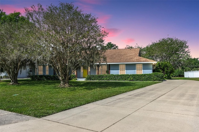 view of front of house with concrete driveway and a front yard