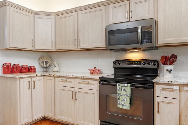 kitchen featuring range with electric cooktop, stainless steel microwave, light brown cabinetry, and backsplash