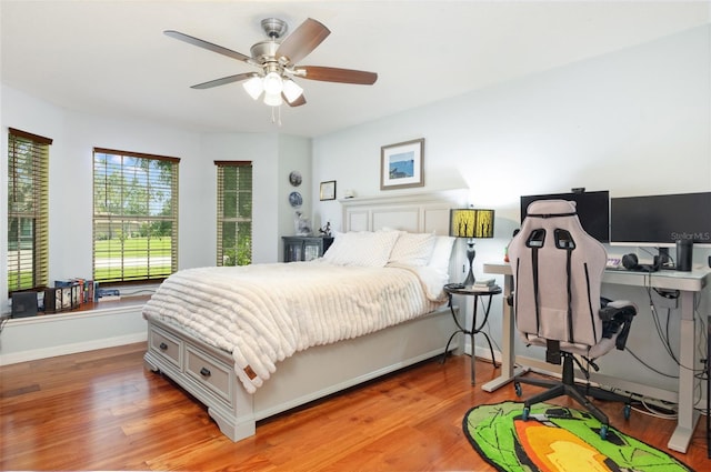 bedroom featuring light wood-style floors, baseboards, and a ceiling fan