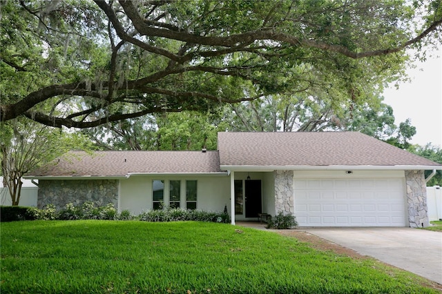 2004 Chickwood Ct, Tampa, FL 33618 - ranch-style home with a front yard, an attached garage, stone siding, stucco siding, and driveway