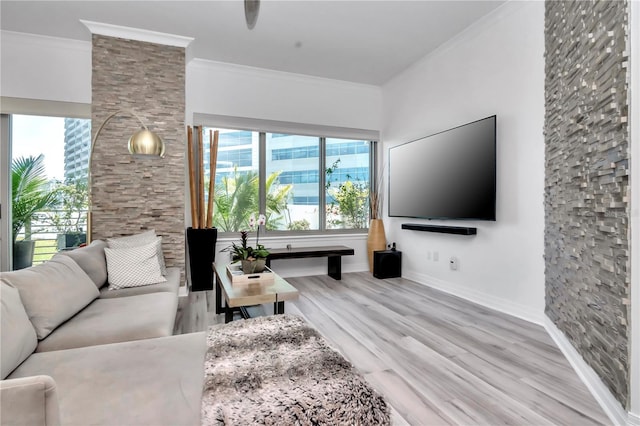 living room featuring baseboards, ornamental molding, wood finished floors, and plenty of natural light