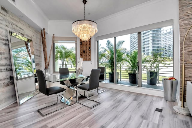 dining room with crown molding, a notable chandelier, and wood finished floors