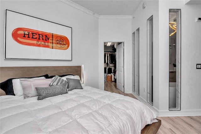 bedroom with ornamental molding, wood finished floors, and baseboards
