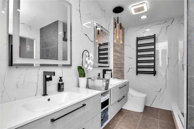 bathroom with tile patterned floors, double vanity, radiator, toilet, and a sink
