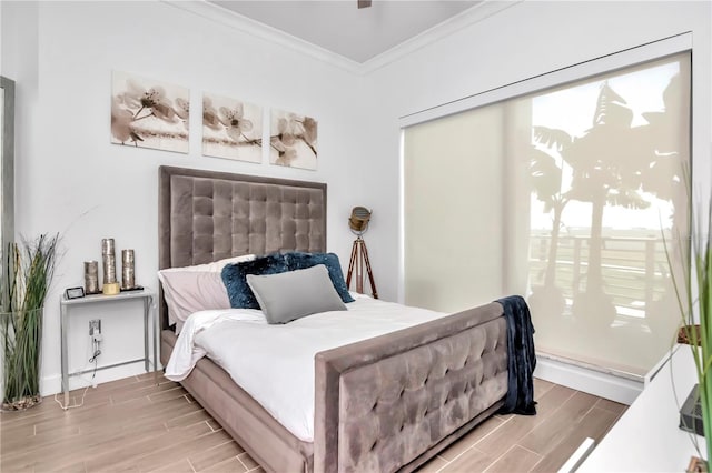 bedroom featuring wood finish floors and crown molding