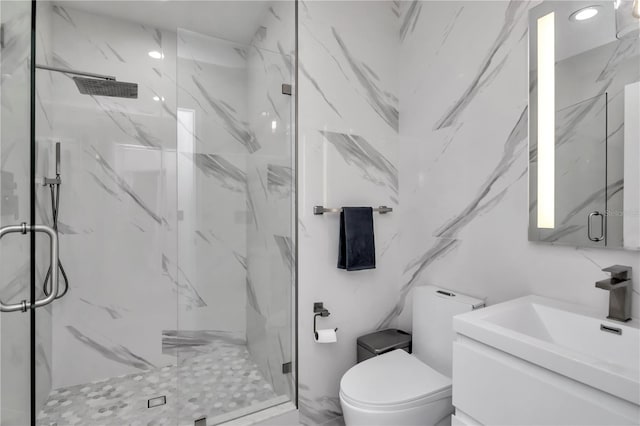 full bath featuring a marble finish shower, toilet, and vanity