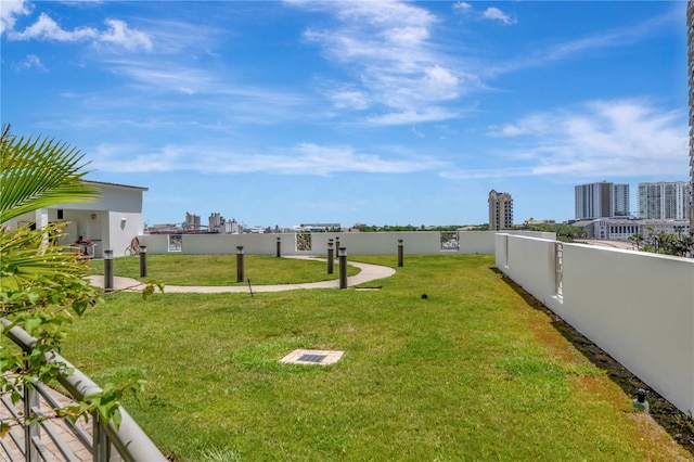 view of yard with fence and a city view