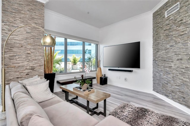 living area with visible vents, wood finished floors, and crown molding