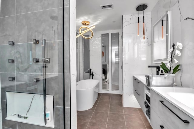 bathroom with a shower stall, a freestanding tub, tile patterned floors, double vanity, and visible vents
