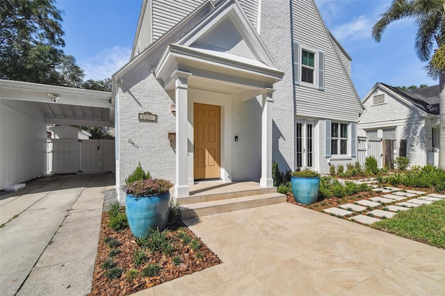 view of front of house featuring a carport, driveway, fence, and a gate