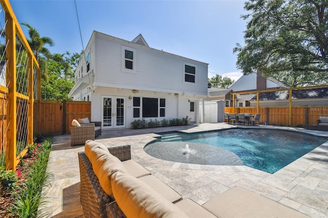 rear view of property featuring a fenced in pool, a patio, french doors, a fenced backyard, and an outdoor hangout area