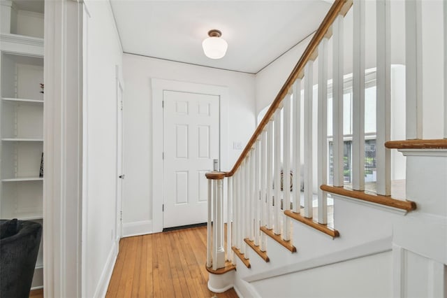 foyer with baseboards, hardwood / wood-style flooring, and stairs
