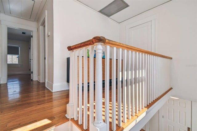 stairway featuring visible vents, baseboards, attic access, and wood finished floors