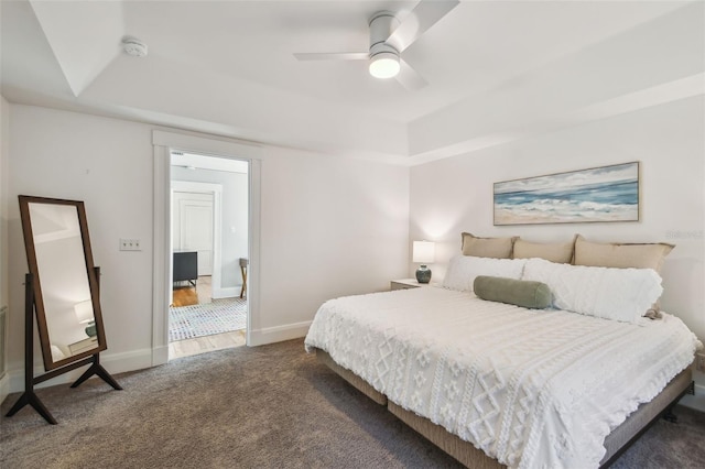 bedroom with a raised ceiling, baseboards, a ceiling fan, and carpet floors