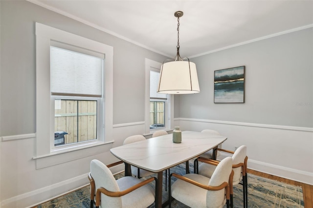 dining room featuring ornamental molding, baseboards, and wood finished floors