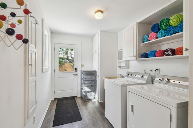 laundry room featuring dark wood-type flooring, washer and clothes dryer, baseboards, and cabinet space