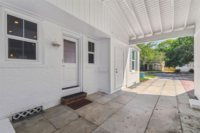 doorway to property with a patio area and board and batten siding