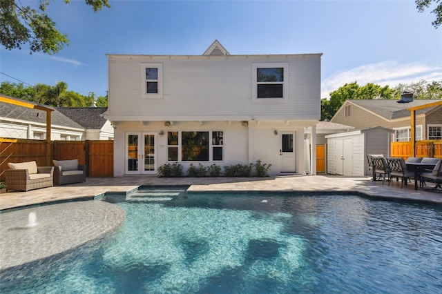 back of house with a fenced in pool, a patio, french doors, a shed, and fence