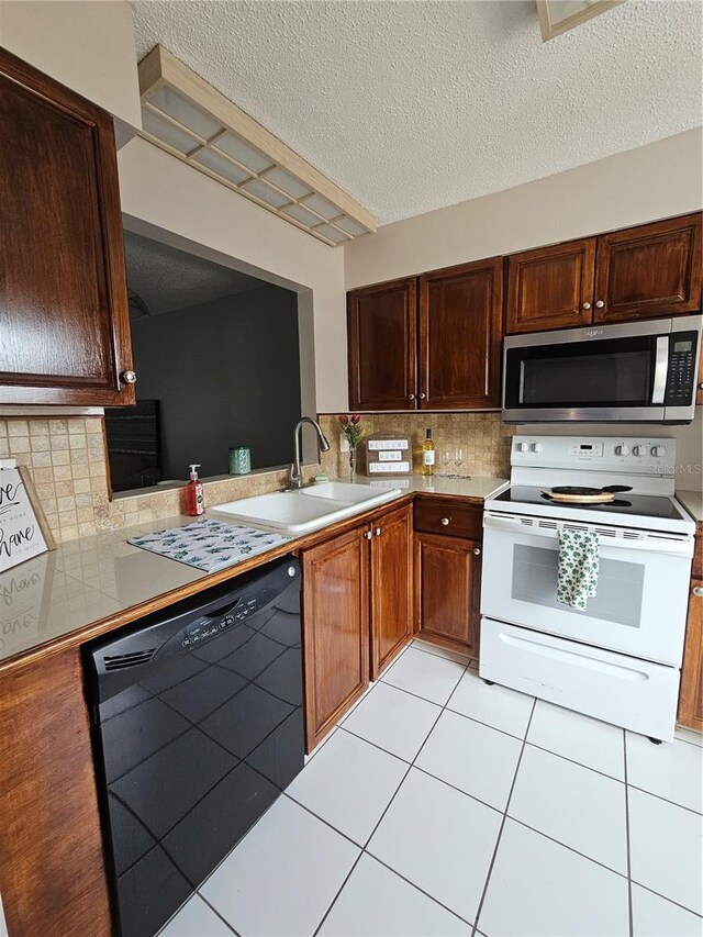 13813 Mission Oaks Blvd, Seminole, FL 33776 - kitchen featuring stainless steel microwave, light countertops, black dishwasher, white electric stove, and a sink