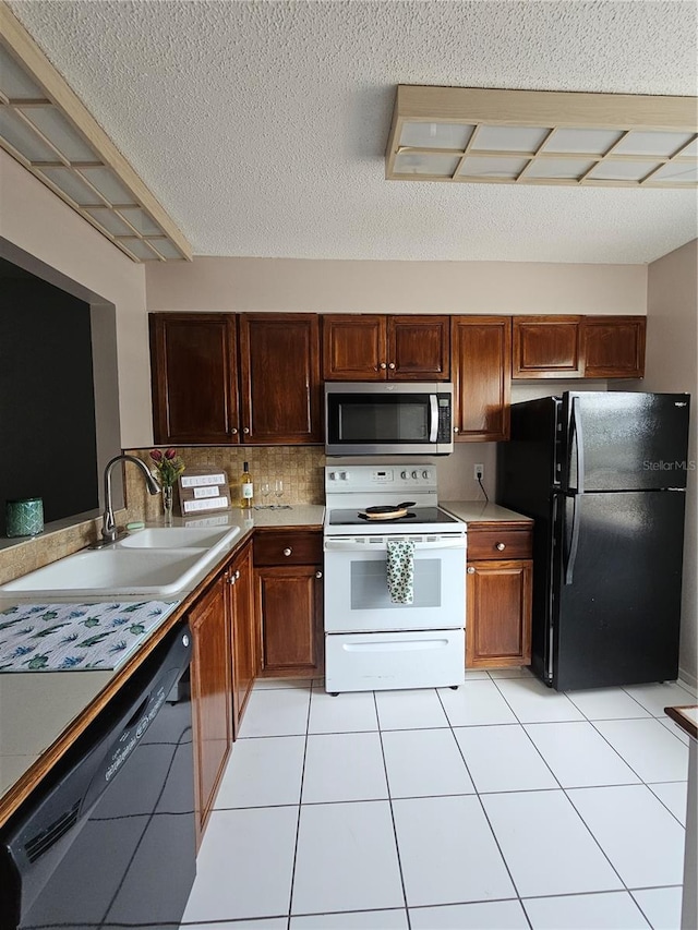 13813 Mission Oaks Blvd, Seminole, FL 33776 - kitchen with black appliances, light tile patterned flooring, light countertops, a sink, and backsplash