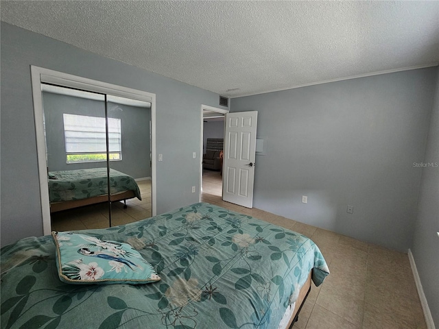 13813 Mission Oaks Blvd, Seminole, FL 33776 - tiled bedroom featuring a textured ceiling, a closet, and visible vents